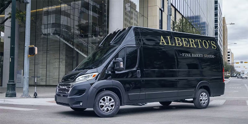 black promaster van driving down a city street
