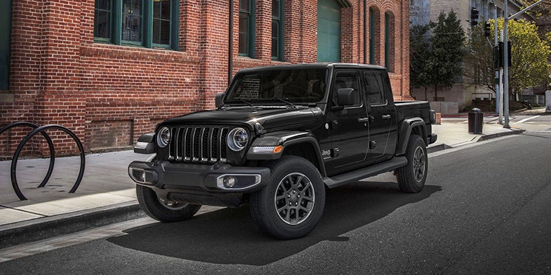 Black 2024 jeep gladiator parked on the street in a city