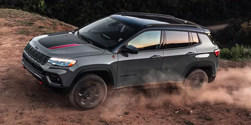 2024 jeep compass driving down a dirt road