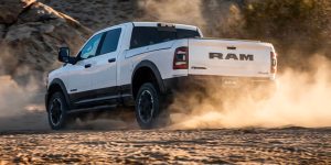 white 2025 ram truck driving down a dirt road